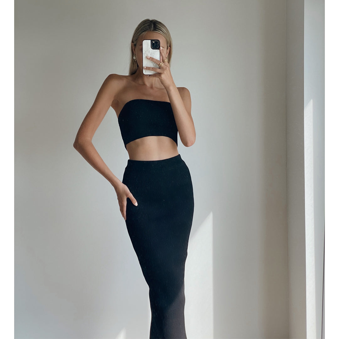 Female model wearing black knit tube crop top with black high waist midi knit bodycon skirt