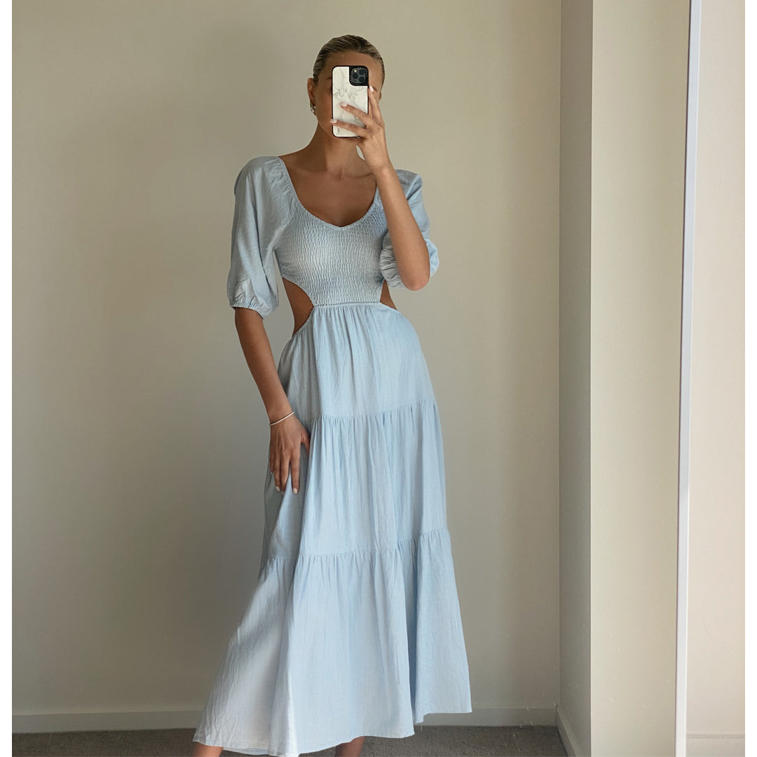 Female model wearing baby blue puff sleeve open back flowy maxi dress