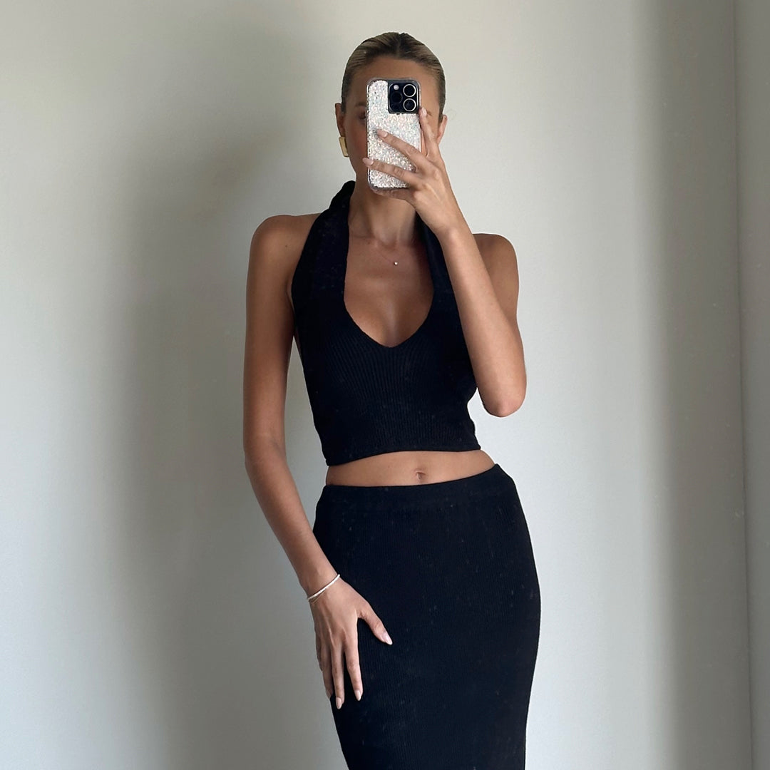 Female model online wearing black halter knit crop top