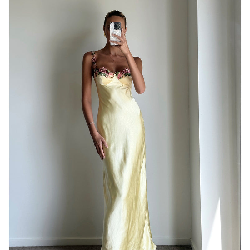 Female model online wearing soft yellow strappy bustier maxi dress