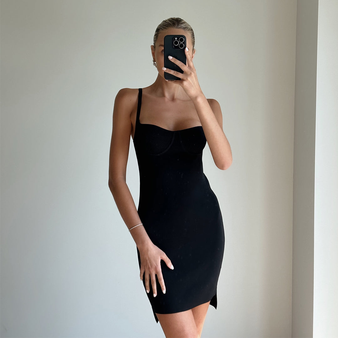 Female model online wearing black mini stappy knit dress