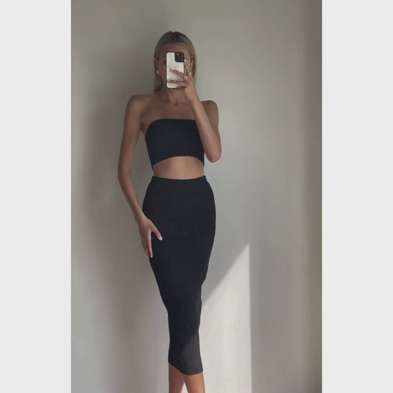 Female model wearing black knit tube crop top with black high waist midi knit bodycon skirt