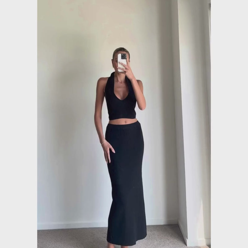 Female model online wearing black halter knit crop top