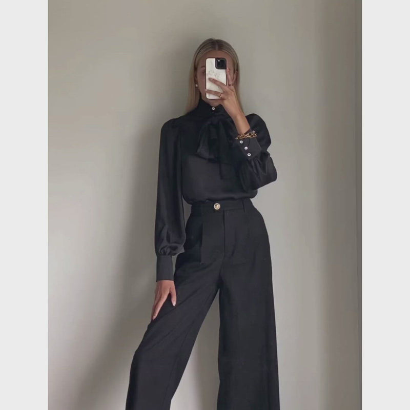 Female model wearing black high waisted wide leg pants