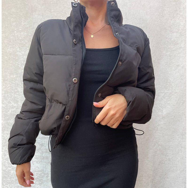 Female model wearing black cropped puffer jacket