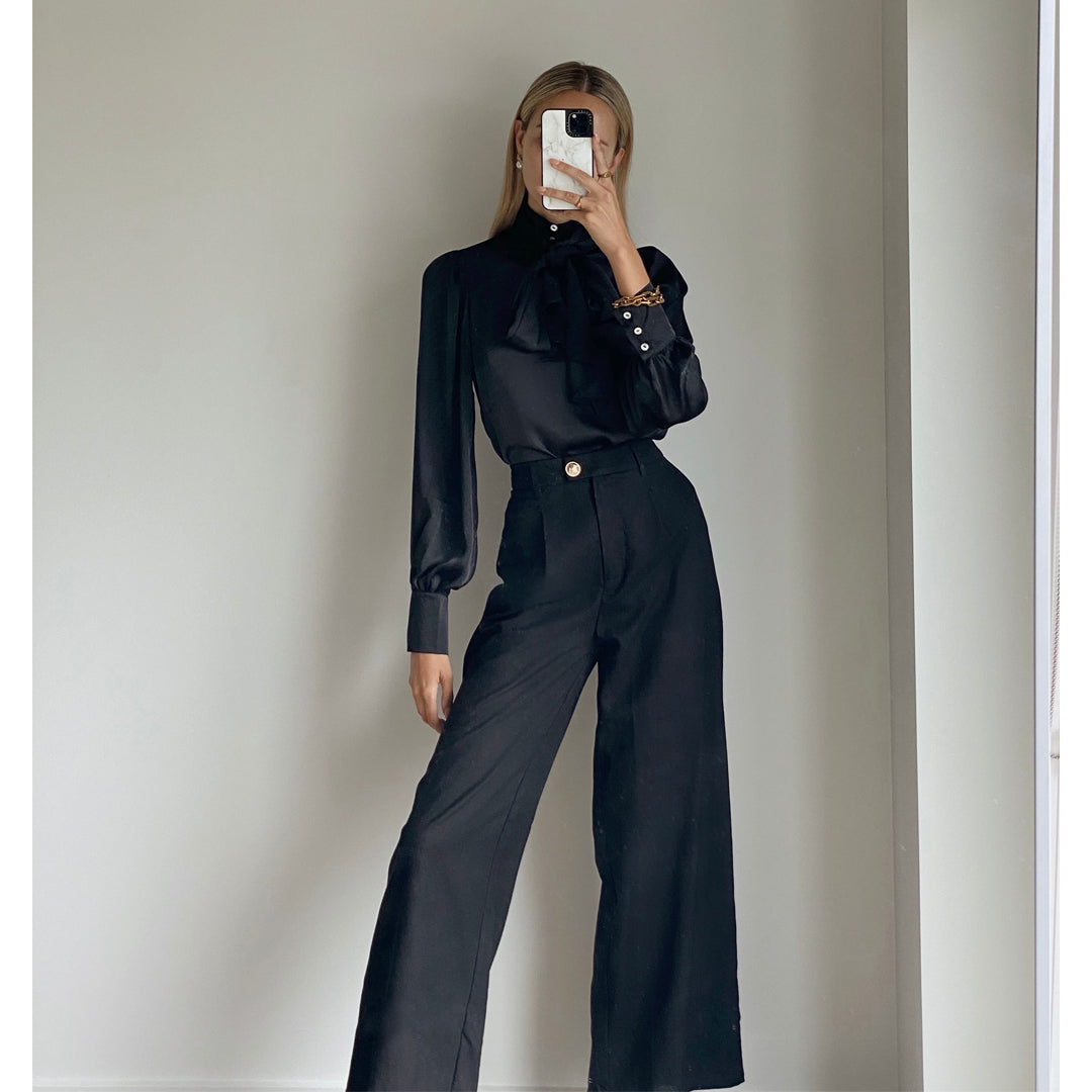 Female model wearing black high waisted wide leg pants