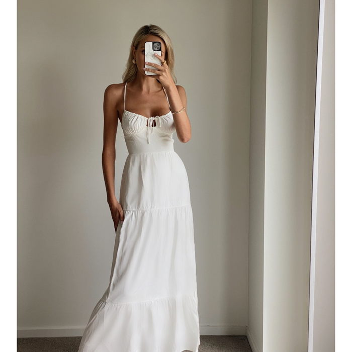 Female model online wearing white strappy flowy maxi dress