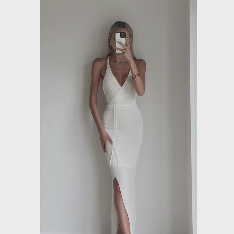 Female model online wearing ivory knit backless maxi dress with front split detail